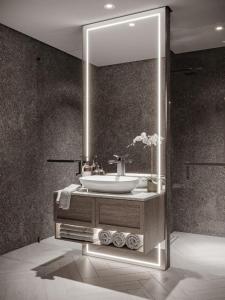 a bathroom with a sink and a mirror at Boutique Loft, Stylish, Cozy and Luxurious style apartment in wonderful building with 2 Pools & Gym in Dubai