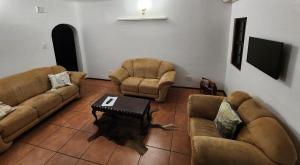 a living room with two couches and a coffee table at Mkumbi Farm Cottage in Hluhluwe