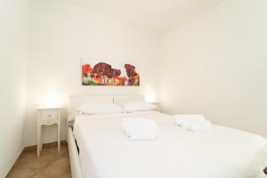 ColonnoにあるSplendida casa con terrazza vista lago e 2 garageの白い部屋のベッド2台 壁に絵画が飾られています。