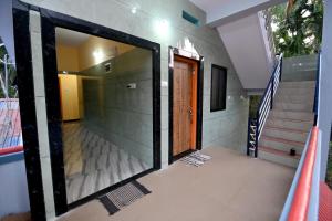a glass door leading into a house with stairs at Louis Homestay in Māvalli
