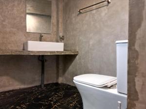 a bathroom with a white toilet and a sink at Suna's Place in Ahangama