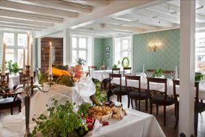 a dining room with tables and chairs with food on them at Hotel Kong Carl - Unike Hoteller in Sandefjord