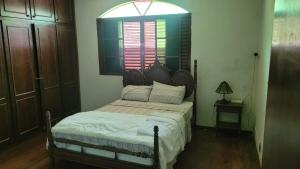 a bedroom with a bed and a window at Pousada Serrana in Coimbra