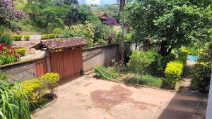 a garden with a fence and a smallshed at Pousada Serrana in Coimbra