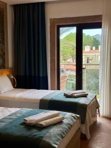 a hotel room with two beds and a window at The Kumsal Hotel Oludeniz in Oludeniz