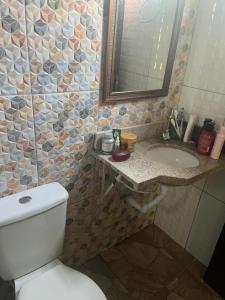 a bathroom with a toilet and a sink and a mirror at Chalé Encantos do Una in Morros +65 photos