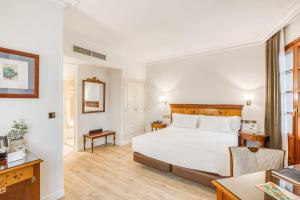 a hotel room with a bed and a desk at Sercotel Arenal Bilbao in Bilbao
