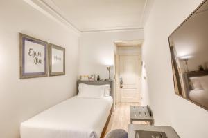 a small white room with a bed and a table at Sercotel Arenal Bilbao in Bilbao +28 photos
