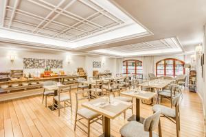 a restaurant with tables and chairs and a counter at Sercotel Arenal Bilbao in Bilbao