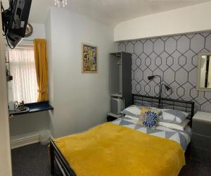 a bedroom with a bed with a yellow blanket at Hornby Villa B&B Couples & Families Only- Quiet Central Location- Near To Winter Gardens in Blackpool +33 photos