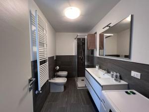 a bathroom with a sink and a toilet and a mirror at Casa Adamello in Corteno Golgi