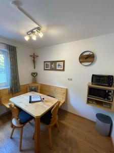 a dining room with a table and a cross on the wall at Kössler, Appartementhaus in Bad Hofgastein +18 photos