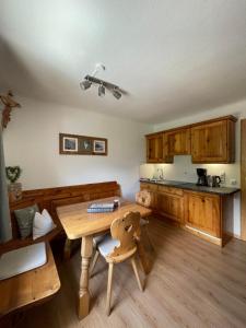 a kitchen with a wooden table and wooden cabinets at Kössler, Appartementhaus in Bad Hofgastein