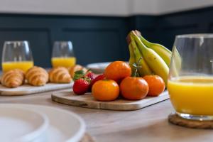 a table topped with oranges and bananas and orange juice at Renovated 3 Bedroom House in Lowton Pennington, free parking in Leigh