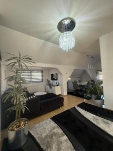 a living room with a black couch and a chandelier at Luxury Studio Black & White in Sarajevo
