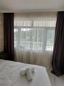 a bed with two towels on it in front of a window at Dezu in Kvariati +37 photos