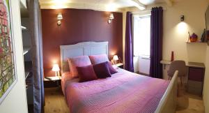 a bedroom with a bed with purple sheets and pillows at 10 min de Cortè, 5 couchages, in Venaco