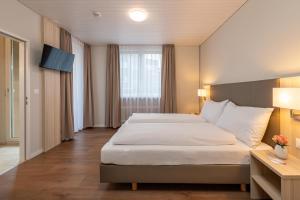 Postel nebo postele na pokoji v ubytování Hotel Garni Rössli