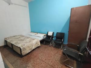 a room with a bed and two chairs in it at Shree Dhaam Homestay in Faizābād