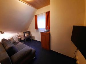 a living room with a couch and a window at Café- Pension Fernblick, incl MeineCardPlus in Willingen