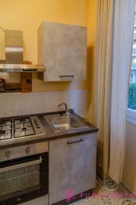 a kitchen with a sink and a stove at La Magnolia del Ducato in Parma