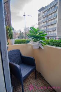 a blue chair sitting on a balcony with a plant at La Magnolia del Ducato in Parma