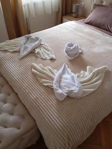 a bed with white towels and a hat on it at Apartment Aleksandrija in Niš +157 photos