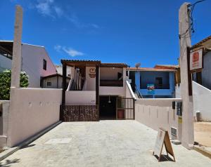 a white house with a sign in front of it at Pousada Balanço do Mar in Praia do Forte
