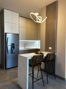 a kitchen with a refrigerator and a table with chairs at Departamento de Lujo, en el centro de Mty in Monterrey
