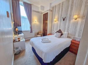 a bedroom with a large white bed and a window at Wharton Arms Hotel in Skelton