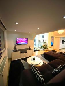 a living room with a couch and a flat screen tv at Luxury Studio Black & White in Sarajevo