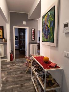 a living room with a table and a painting on the wall at AppartamentoMonika con parcheggio privato - Volano in Volano