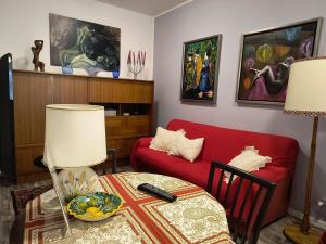 a living room with a red couch and a table at AppartamentoMonika con parcheggio privato - Volano in Volano