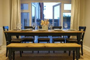 a dining room table with chairs and wine glasses at Bicester Villa - 6 Bed - Sleeps 14 in Bicester