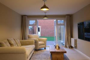a living room with a couch and chairs and a window at Bicester Villa - 6 Bed - Sleeps 14 in Bicester