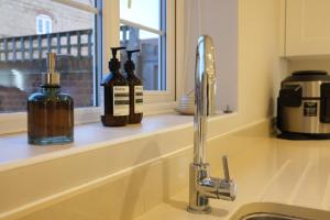 a sink with two bottles on a counter next to a window at Bicester Villa - 6 Bed - Sleeps 14 in Bicester +41 photos
