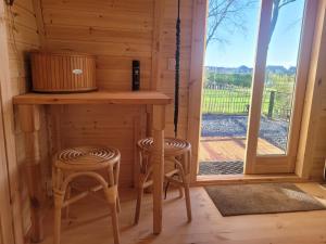 a small table and two stools in a room with a window at B&B De SluisPod in Hoogeveen