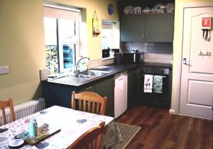 a kitchen with a table and a sink and a table and chairs at Heather Cottage Doolin in Doolin