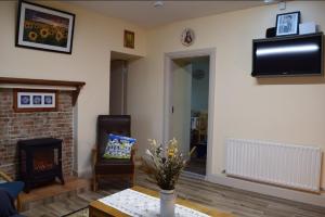 a living room with a fireplace and a tv at Heather Cottage Doolin in Doolin