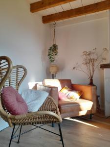 a living room with a couch and a chair at New Woodys Vakantiehuisje Rust aan de Zeeuwse kust in Hoofdplaat