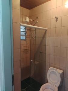 a bathroom with a toilet and a shower at Apartamento em Ubatuba Arejado Próximo a Praia in Ubatuba