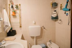 a small bathroom with a toilet and a sink at Dona Ana Beach Apartment in Lagos