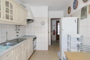 a kitchen with a sink and a refrigerator at Dona Ana Beach Apartment in Lagos