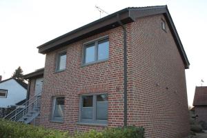 a red brick house with a gambrel roof at Ferienwohnung Walgernheide in Warendorf +11 photos