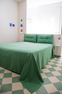 a green bed in a room with a checkered floor at B&B Casa Ruffino in Balestrate