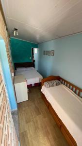 two beds in a room with green walls at Hostel Vento Leste in Bombinhas