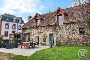 a stone house with a table and chairs in front of it at Domaine de la motte in Plourhan