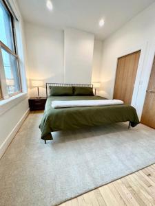 a bedroom with a large bed with a green blanket at Condo C - Gallery Suites Downtown Marion in Warren
