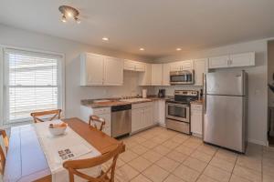 a kitchen with white cabinets and a table and a refrigerator at Loft on Landess in Marion