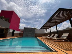 a pool on the roof of a building with chairs at Hotel Mesón de la Chinantla in San Juan Bautista Tuxtepec